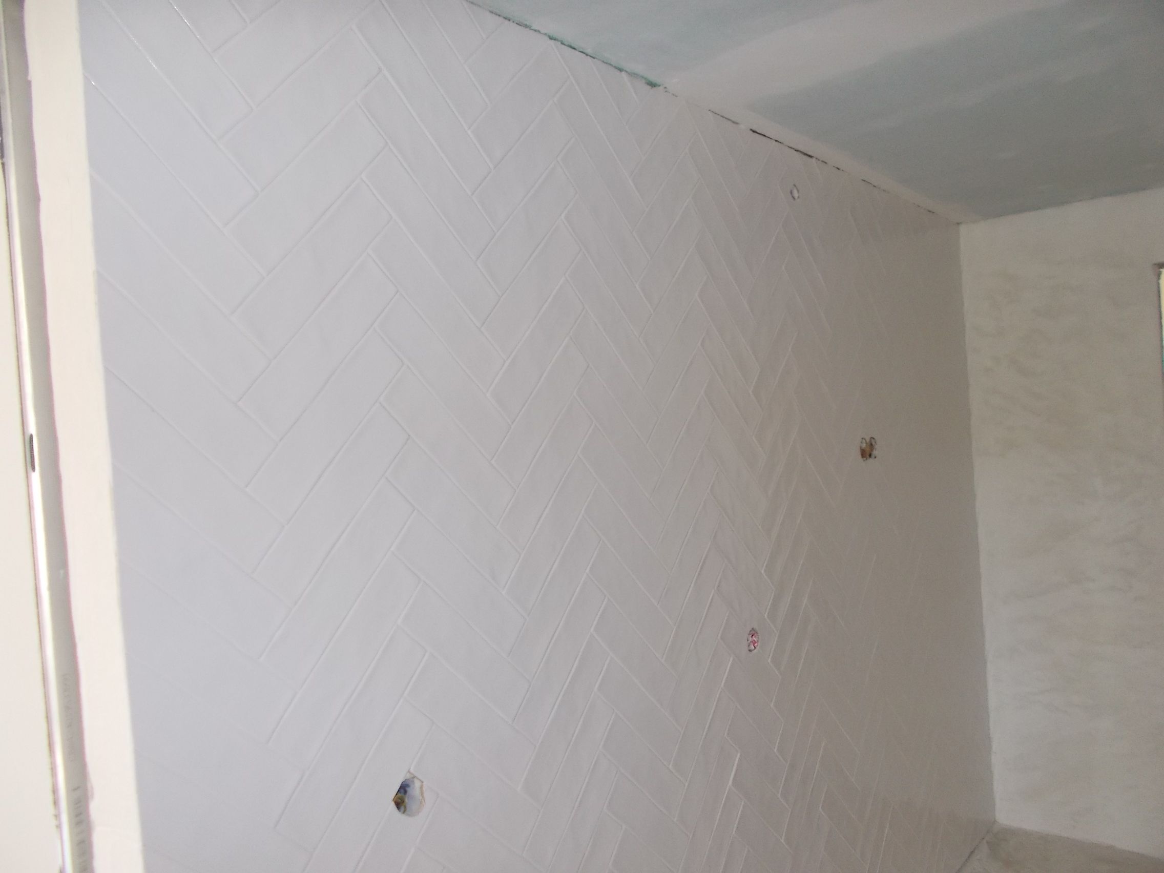 Fotografia de uma parede em azulejo branco